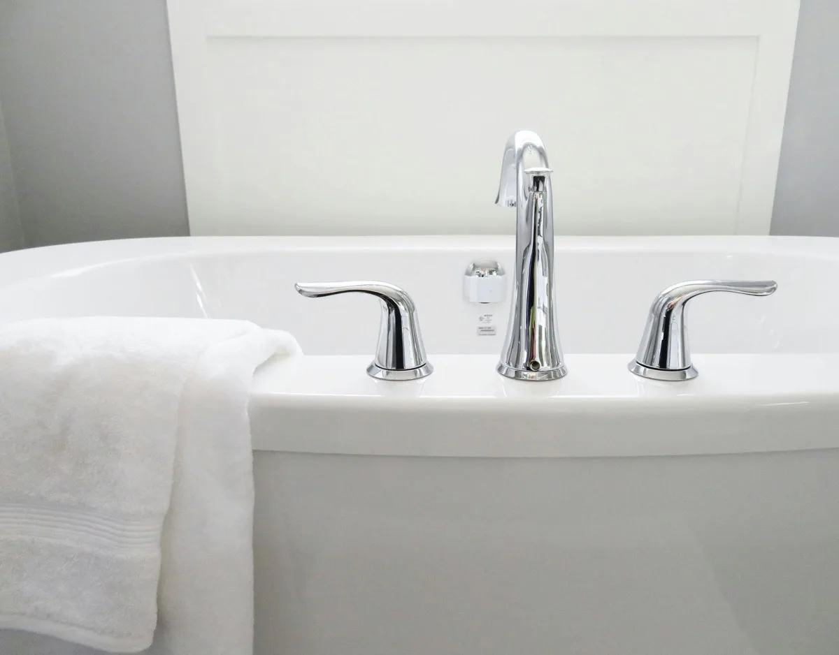 Renovated bathroom with a grey shaker vanity and herringbone tub surround