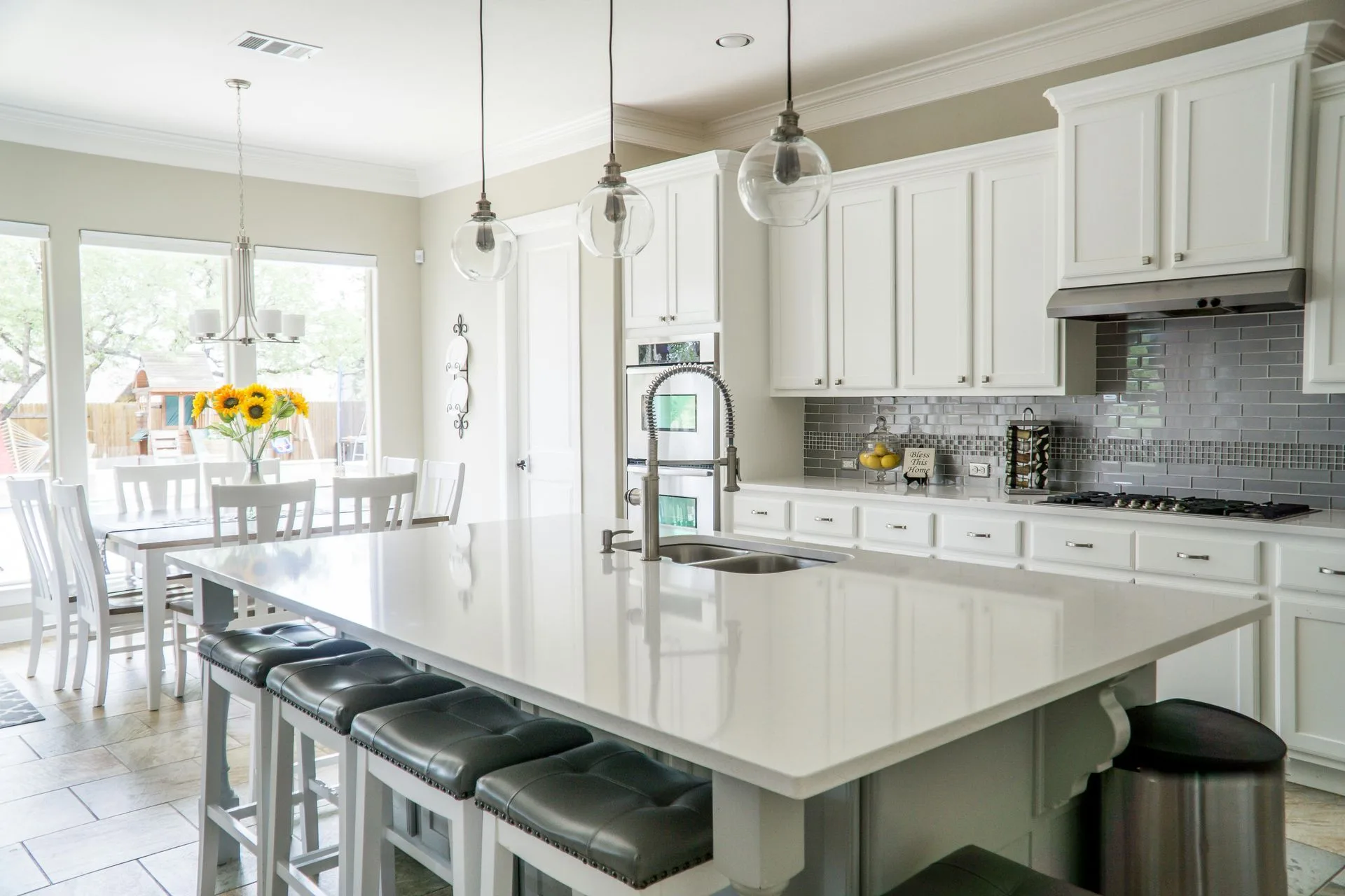 Wide view of a white shaker kitchen with quartz island and breakfast area